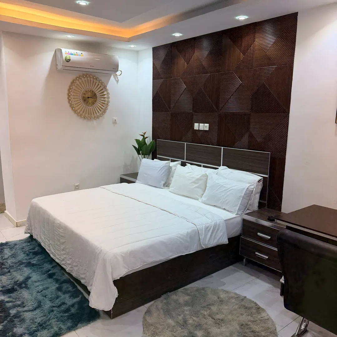 Chambre Single : grand lit, panneau mural en bois sculpté et bureau